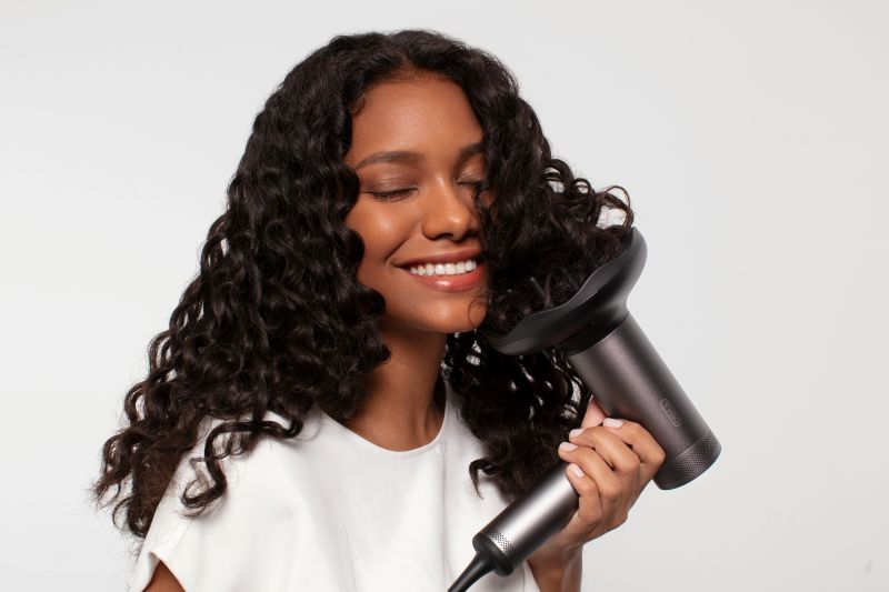 Florida woman using round brush during at-home blowout